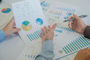 A team of business people is brainstorming to analyze investment project data. photo