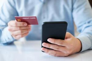 A man is using his phone to pay for a credit card photo