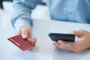 A man is using his phone to pay for something with a credit card photo