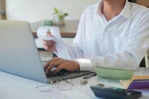 Accountant filling in items from a bill and use computers to calculate financial budgets photo