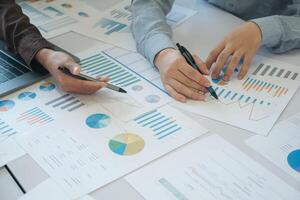 A team of business people is brainstorming to analyze investment project data. photo