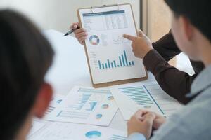 A team of business people is brainstorming to analyze investment project data. photo