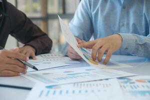 A team of business people is brainstorming to analyze investment project data. photo