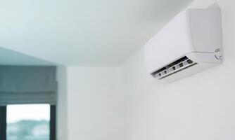 Modern air conditioner unit on a white wall photo