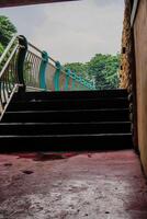 close view of the stairs leading to the garden with the fence dividing the river. photo