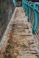 cobblestone paths with many different colors and small stones in the form of tiles with iron guardrails. photo