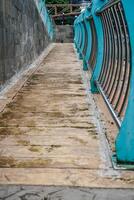 cobblestone paths with many different colors and small stones in the form of tiles with iron guardrails. photo