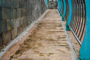 cobblestone paths with many different colors and small stones in the form of tiles with iron guardrails. photo