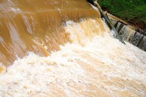 eso mira cerca a el desviación de turbio agua ese fluye rápidamente más allá el Perímetro represa. foto