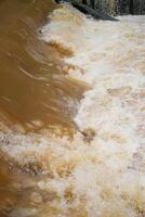 eso mira cerca a el desviación de turbio agua ese fluye rápidamente más allá el Perímetro represa. foto