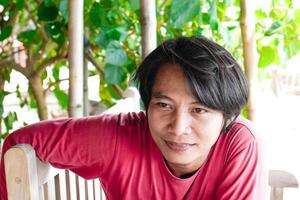 a close-up of the face of a Javanese man who appears to have long hair. photo