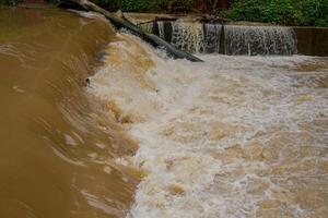 eso mira cerca a el desviación de turbio agua ese fluye rápidamente más allá el Perímetro represa. foto