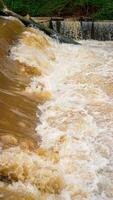 eso mira cerca a el desviación de turbio agua ese fluye rápidamente más allá el Perímetro represa. foto