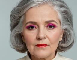 Gray-haired woman with pink makeup photo