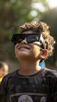 un joven chico vistiendo protector lentes es acecho el solar eclipse. foto