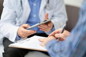 Professional medical doctor in white uniform gown coat consulting with patient photo