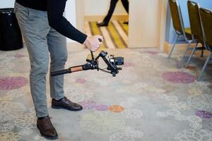 Steadicam in the hands of the cameraman, a stabilizer for shooting from the hands, the guy shoots a movie on the balancer for the camera, a stable position of the technique. photo