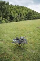 A set of tourist utensils is on the table at the campsite, light equipment, a compact size of equipment, a set of cutlery for a picnic. photo