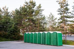 al aire libre cabañas de el compostaje baño estar en uno fila en el cuadrado en el ciudad parque, un el plastico caja para el baño. foto