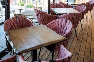 hermosa interior de un al aire libre cafetería, de madera mesa, suave sillas de rosado color, un aire libre restaurante, un sitio para almuerzo de los ciudadanos foto