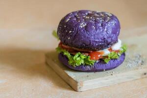 cerca arriba foto de un hecho en casa púrpura hamburguesa metido en un cerámico mesa