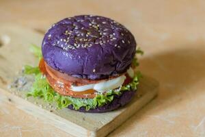 cerca arriba foto de un hecho en casa púrpura hamburguesa metido en un cerámico mesa