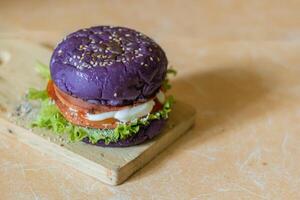 cerca arriba foto de un hecho en casa púrpura hamburguesa metido en un cerámico mesa