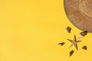 Summer composition. Straw hat, sea shells and starfish on yellow background. Summer concept. Flat lay banner, top view, copy space. Marina style. photo