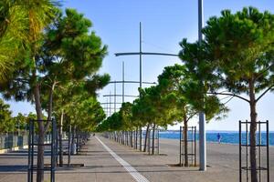 corriendo hombre, acera guía líneas para visualmente dañado Entre pino arboles en el paseo marítimo Tesalónica Grecia foto