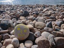 Sea background and pebbles. Sea pebbles on the beach. Natural sea stones closeup. Tourism and travel themed. Smile on the sea pebble photo