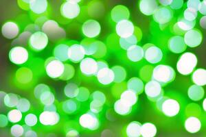 Blurred bokeh magical background. Green and white gradient. Shimmer confetti pattern. Abstract christmas and new year holidays effect. Festive blue luminous background. photo