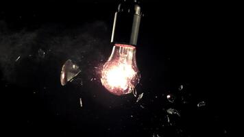 Super slow motion light bulb breaks into rattles. On a black background. Filmed on a high-speed camera at 1000 fps.High quality FullHD footage video