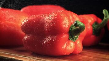 Water droplets fall on the pepper on the cutting board. On a black background. Filmed is slow motion 1000 fps. video