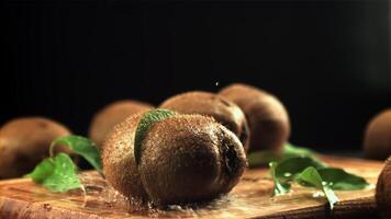 The kiwi falls and splits into two halves. On a black background. Filmed is slow motion 1000 frames per second. video