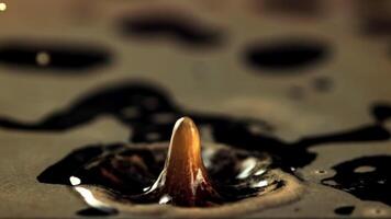 A drop of spray falls into the black coffee. Macro background. The texture of the coffee. Filmed is slow motion 1000 frames per second. video