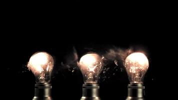 super lent mouvement Trois lumière ampoules exploser. sur une noir arrière-plan.filmé sur une haute vitesse caméra à 1000 ips. video