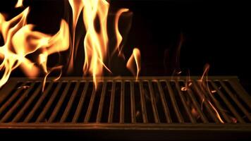 A bright flame of fire burns through the grill. On a black background. Filmed is slow motion 1000 frames per second. High quality FullHD footage video