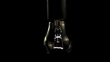 Super slow motion light bulb starts to glow. On a black background. Filmed on a high-speed camera at 1000 fps. High quality FullHD footage video