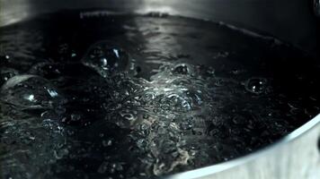 A pot of liquid heating on stovetop creates bubbles, resembling a boiling cauldron. The water inside simmers like gas in an automotive tire video