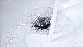 A stream of water pours from the open tap into the sink. High quality FullHD footage video