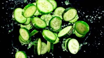 Sliced cucumbers, a versatile vegetable and staple food, are ready to be used as an ingredient in various recipes on the black surface video