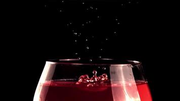 Super schleppend Bewegung fallen Stürze in ein Glas von Wein mit Spritzer.gefilmt auf ein schnelle Geschwindigkeit Kamera beim 1000 fps. auf ein schwarz Hintergrund. video