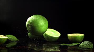 lime cascate su il tavolo. su un' nero sfondo.filmato è lento movimento 1000 fps. video