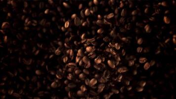 Super slow motion coffee beans soar upwards. Macro background. Top view.Filmed on a high-speed camera at 1000 fps. High quality FullHD footage video