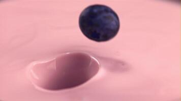 Super slow motion fresh blueberries fall into the yogurt. Macro background. Filmed on a high-speed camera at 1000 fps.High quality FullHD footage video