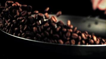 Super slow motion of coffee beans roasted in a frying pan. On a black background. Filmed on a high-speed camera at 1000 fps. video