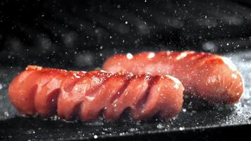 Super slow motion sausages are fried in a pan. High quality FullHD footage video