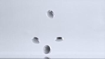 Pills fall on the table. On a white background.Filmed is slow motion 1000 frames per second. High quality FullHD footage video