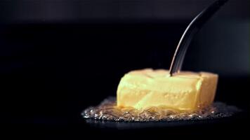 Super slow motion a piece of butter with a fork melts in a frying pan. Filmed on a high-speed camera at 1000 fps. High quality FullHD footage video