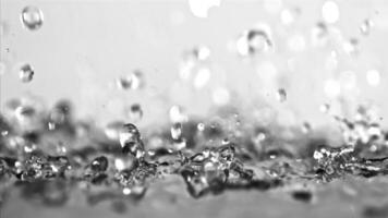 Stunning monochrome photos capture water in various forms, from splashing on a white surface to bubbles in a glass. The beauty of liquid is showcased in closeup macro photography video